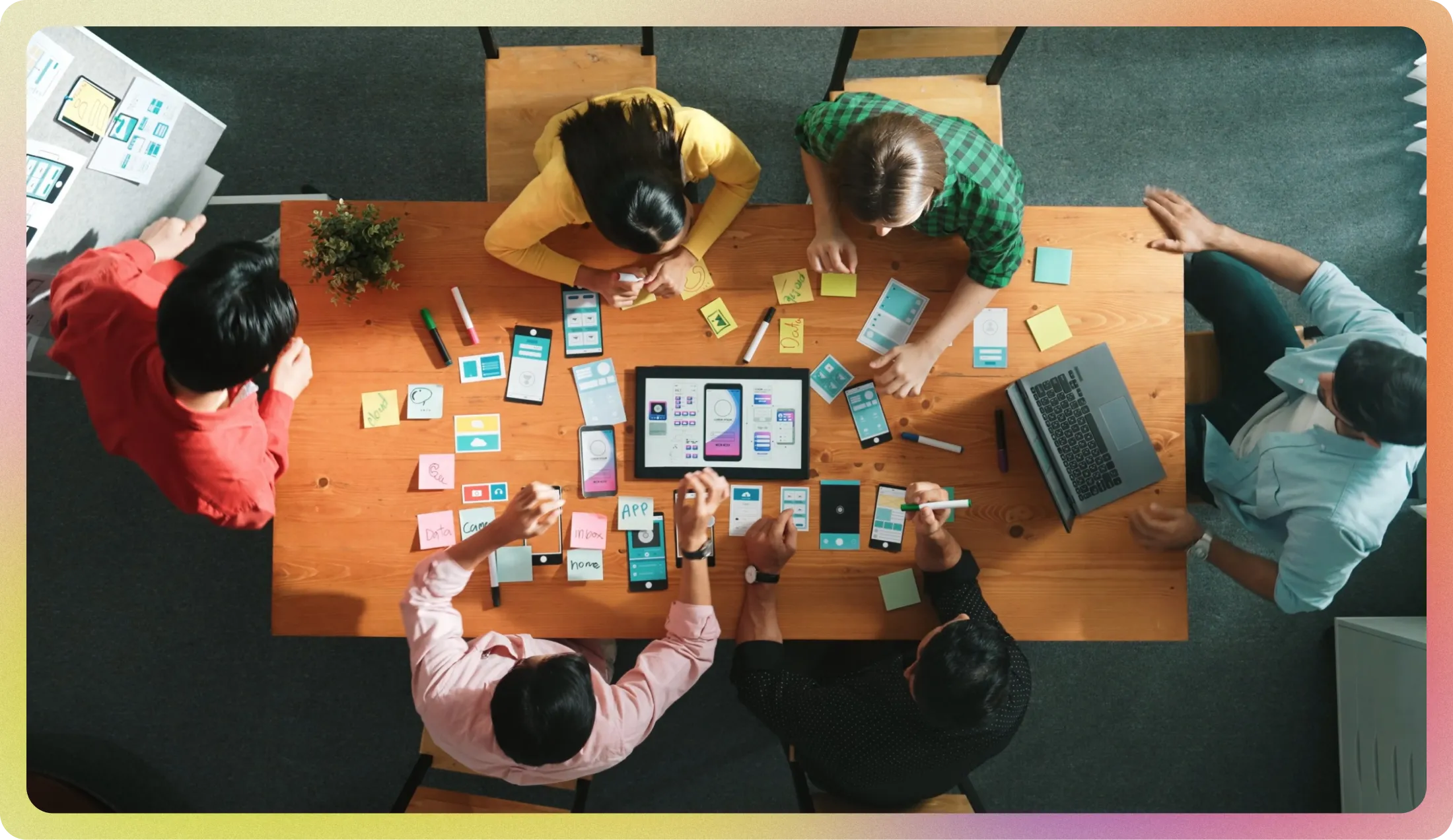 회의실에서 홈페이지 UI 기획을 위해 포스트잇과 와이어프레임을 정리 중인 스타트업 팀원들